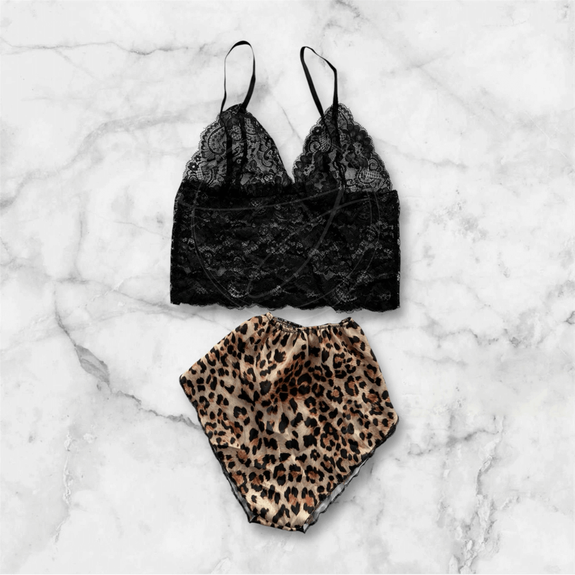 Chic black lace bralette and leopard print shorts set against marble backdrop, offering feminine style and comfort for fashion lovers.